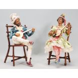 A pair of 20th Century ceramic continental creole band figures seated upon bamboo chairs playing