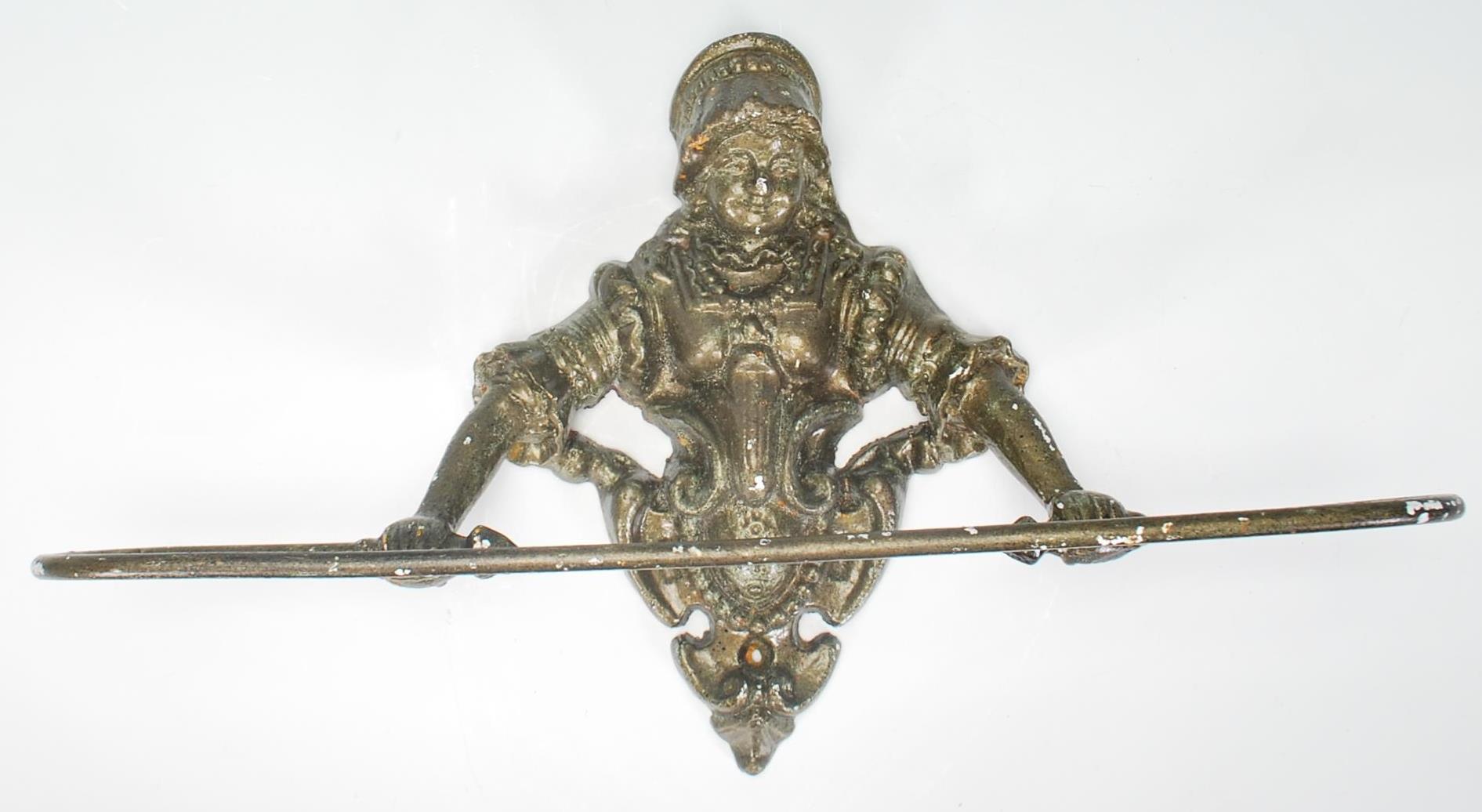 A 20th Century cast iron wall mounting towel rack, the mount in the form of a Victorian lady above