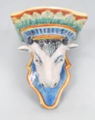 A 20th Century Majolica wall mounting bracket in the form of a bulls head above a shaped base with