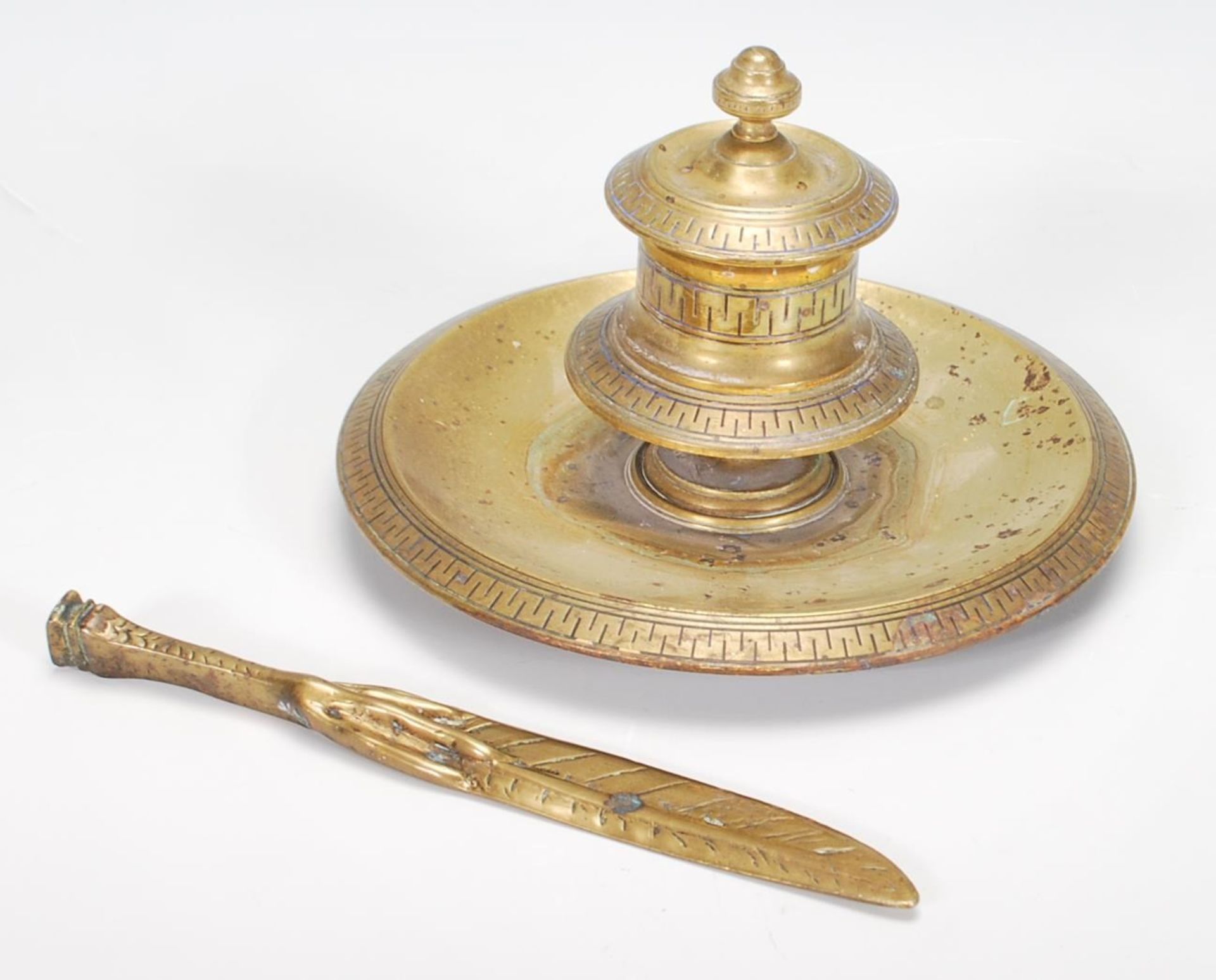 A Victorian 19th century brass desk top single inkwell. Raised on a circular tray pen base with