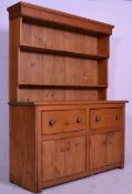 A vintage 20th Century pine dresser having a stepped open shelved upright gallery plate rack over