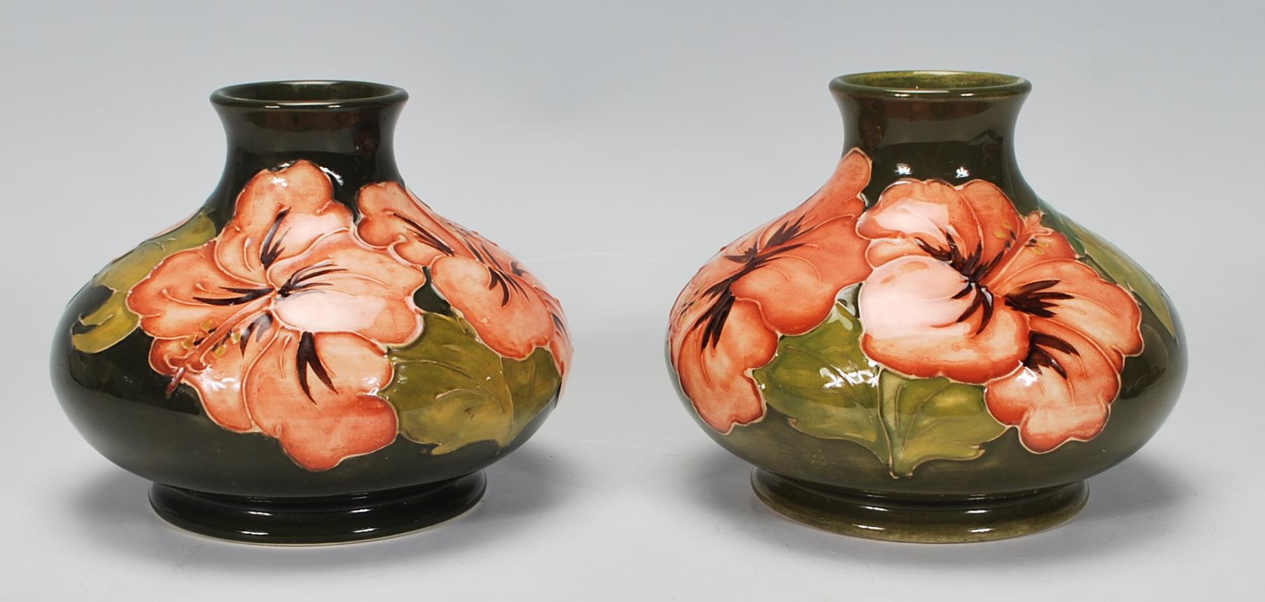 Walter Moorcroft - A pair of Moorcroft tubelined Hibiscus pattern vases of squat globular form