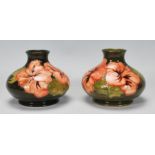 Walter Moorcroft - A pair of Moorcroft tubelined Hibiscus pattern vases of squat globular form