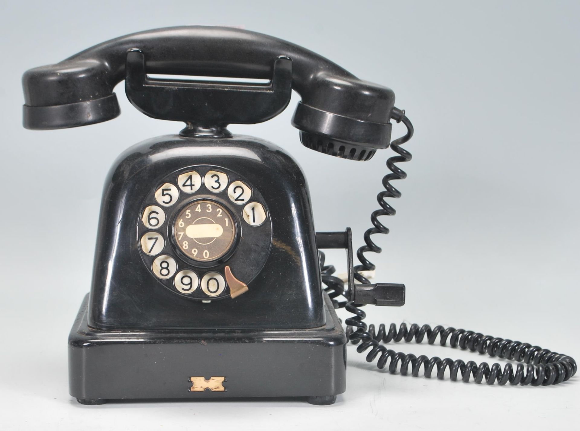 A vintage retro mid Century early plastic telephone having a domed body with rotating dial and