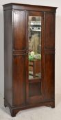 An early 20th Century Gothic revival dark oak wardrobe of good proportions having a single