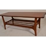 A 20th Century retro vintage teak wood coffee table having a shaped top and magazine rack bellow,