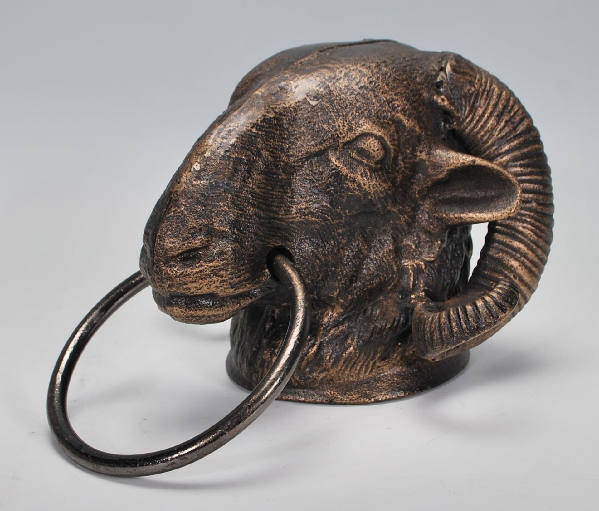 An antique style cast iron door knocker in the form of a Rams head. Measures 13 cm high x 21 cm