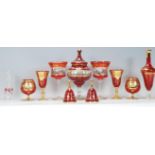 A collection of vintage red / ruby Bohemian glass style vessels to include a lidded vase of