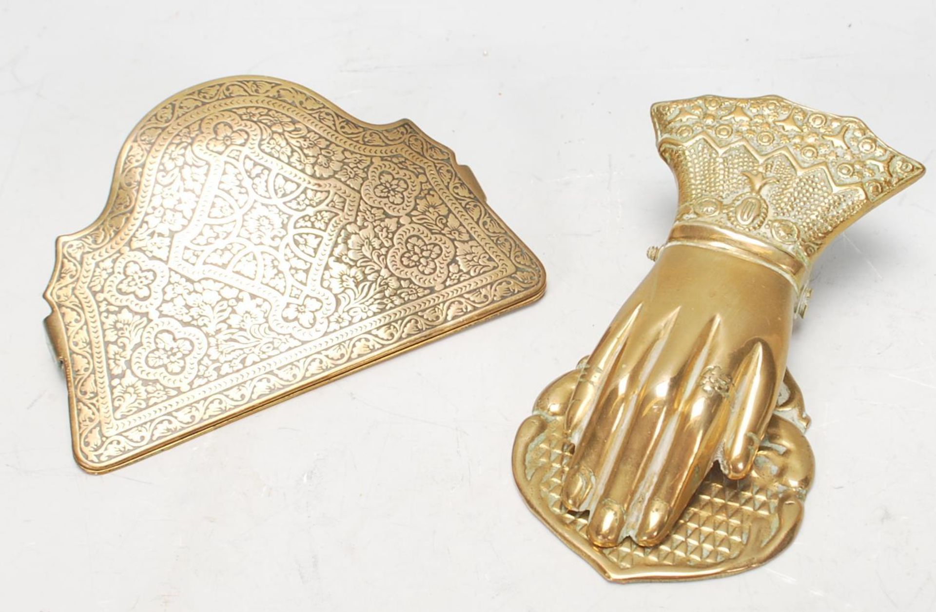 A pair of antique brass wall mounting paper clips to include one in the form of a hand with a