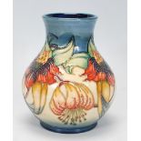 A Moorcroft vase of globular form in the Anna Lilly pattern. Tubelined on a blue and cream ground.