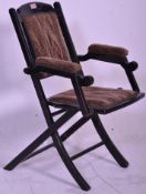 An early 20th Century ebonised mahogany folding chair of simple construction having fabric seat