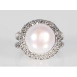 A ladies stamped 925 silver ring set with a large freshwater pearl which are surrounded by Cubic