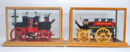 Two good quality glass cased models of horse drawn stagecoach / carriages. Both having coach lights,