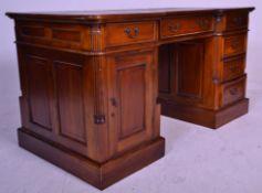 An antique style mahogany and leather inverted breakfront twin pedestal desk. Raised on plinth bases