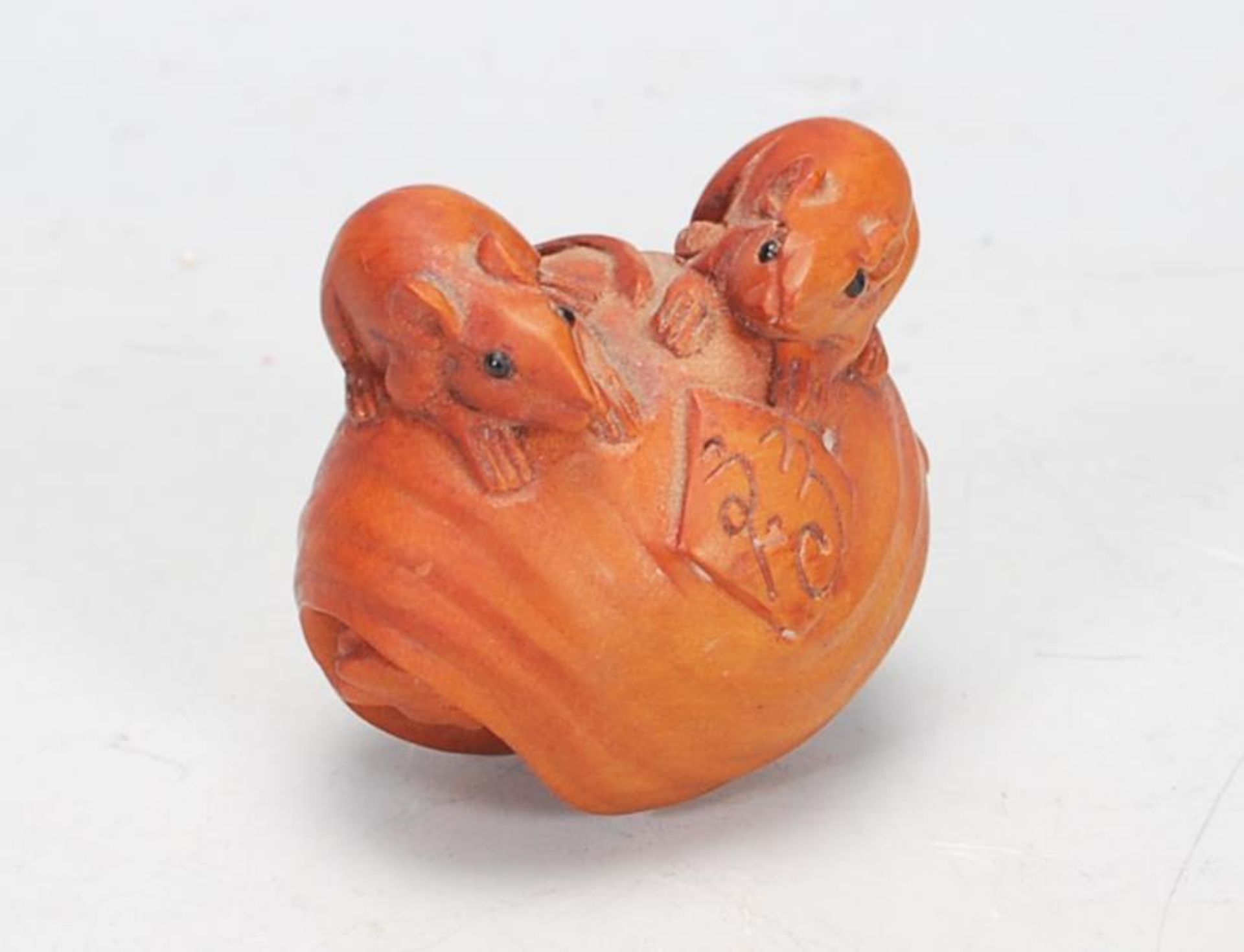 A Japanese carved wood Netsuke toggle in the form of two rats perched on a sea shell with a third