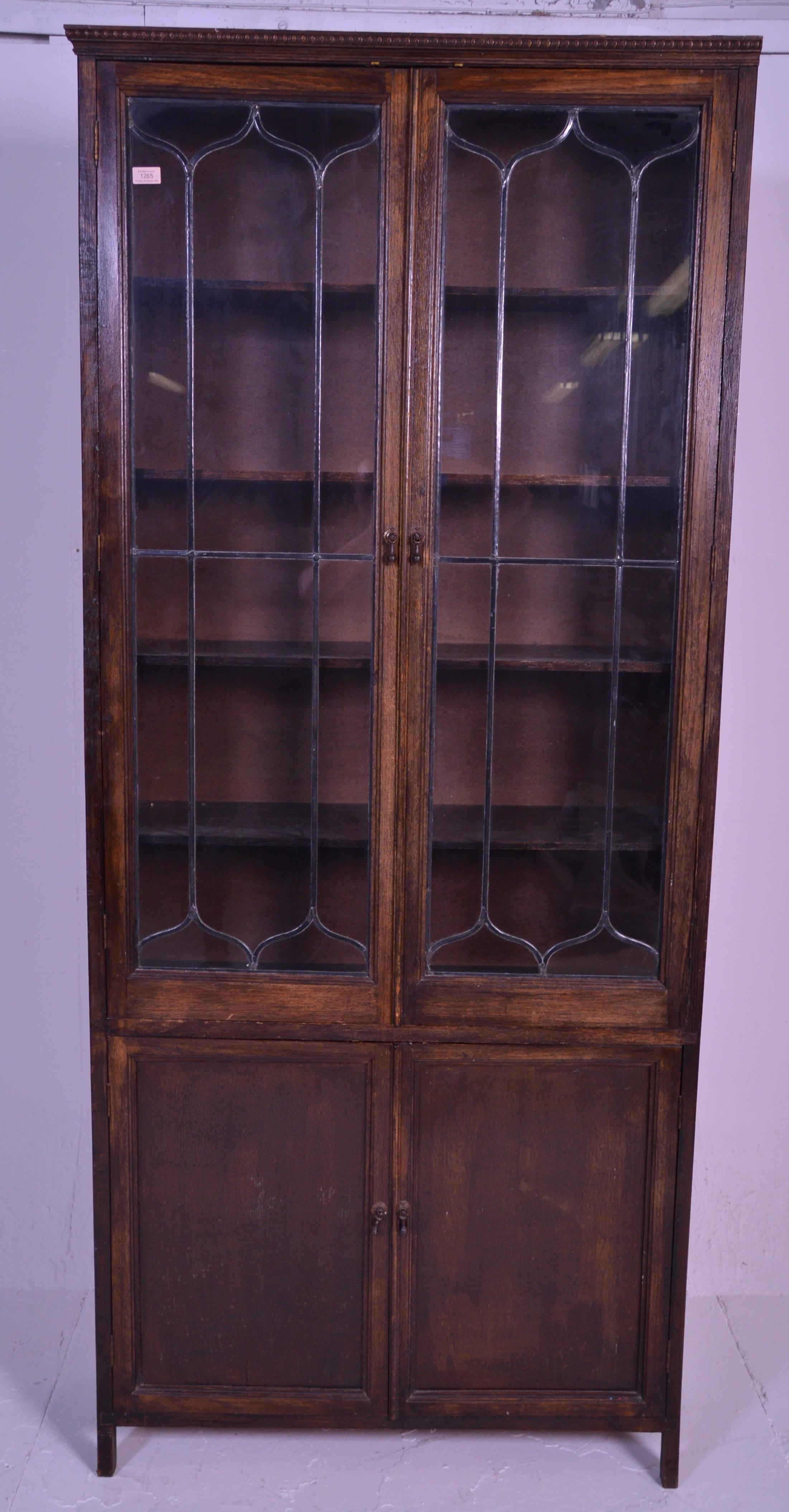 An early 20th Century 1920's oak bookcase having twin glazed lead lined glass doors over two oak - Image 2 of 5