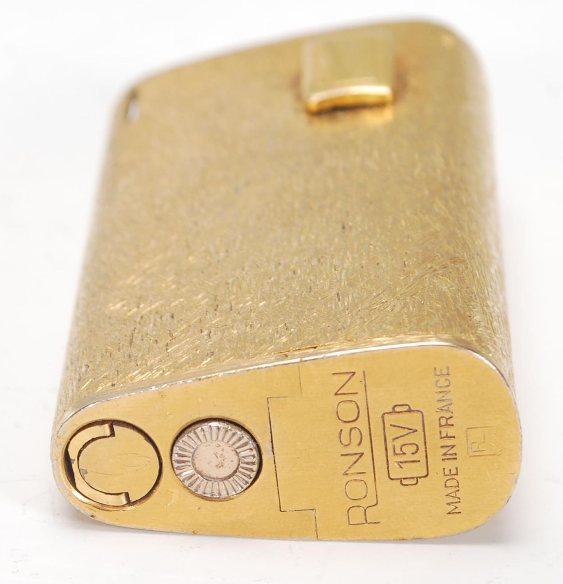 A vintage mid 20th Century Ronson 15V cigarette lighter having a gilt finish of curved triangular - Image 5 of 6