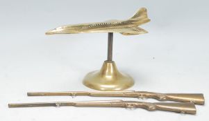 A good brass moulded desk figure of Concorde with cut window detailing raised on a circular base.