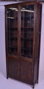 An early 20th Century 1920's oak bookcase having twin glazed lead lined glass doors over two oak