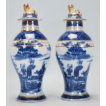 Two early 19th Century blue and white pearlware lidded baluster vases having transfer printed