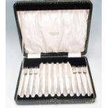 A vintage silver plated cake knife and fork set consisting of six knives and forks set within its