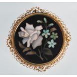 A 20th Century Pietra Dura brooch of round form decorated with contrasting stones in the form of a