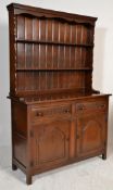 A 20th Century antique style oak dresser having twin cupboard doors with two drawers above each