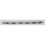 A ladies silver spacer bracelet. Linked alternately with panels set with marcasites and mother of