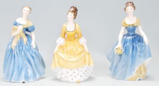 A group of three Royal Doulton lady figurines to include Adrienne HN 2304, Melanie HN 2271 and a