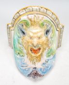 A 20th Century majolica wall bracket in the form of Bacchus modelled with scrolled acanthus leaves