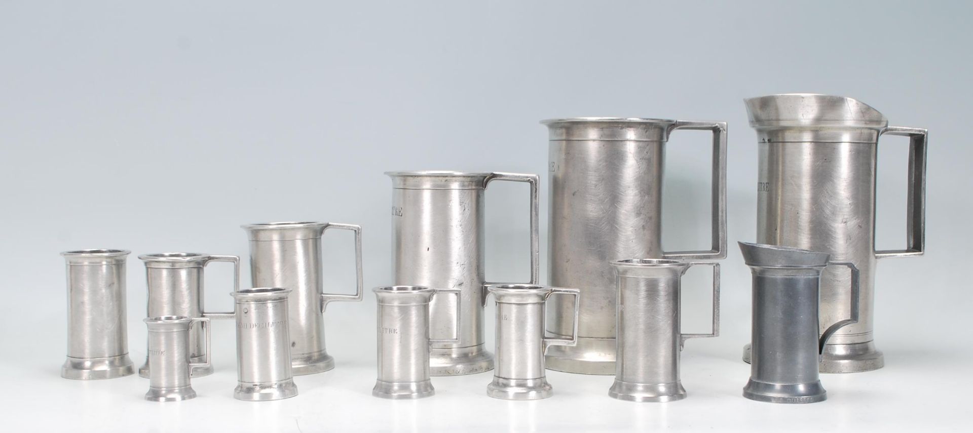 A group of 19th Century French pewter measuring tankards of graduating sizes. Many bearing stamps to