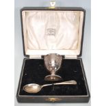 A silver hallmarked engraved child's egg cup and spoon christening set, the spoon and cup each chase