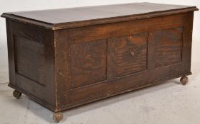 A 20th Century oak ottoman chest having a panelled front with an overhanging hinged lid raised on