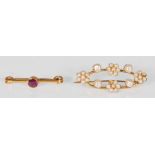 A stamped 9ct gold bar brooch set with a central rounf cut pink stone (measures 3cm wide) together