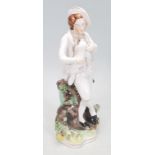 A 19th Century Staffordshire figurine in the form of a man holding a puppy leaning on a tree stump