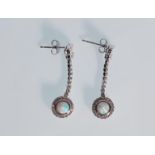 A pair of ladies silver drop earrings. Stamped 925. Cubic Zirconia are set in a knot with the drop