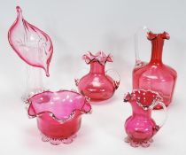 A small group of vintage 20th Century cranberry glassware to include a leaf vase, large and small