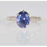 A 9ct yellow gold ladies dress ring set with an oval faceted cut blue stone with illusion set