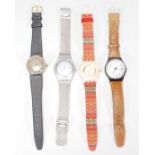 A group of three Swatch watches to include a silver tone bracelet watch, a brown leather strapped