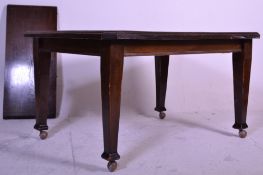 A large early 20th Century oak extending dining table of rectangular form having canted corners with