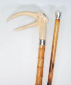 A pair of 20th century wooden walking sticks, having deer antler handle on a bamboo effect shaft