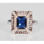 A stamped 925 silver dress ring. Set with an emerald cut faux sapphire which is surrounded by