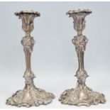 A pair of 20th Century silver plated candlesticks having floral scones to the tops, raised on reeded