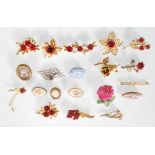A selection of vintage mid 20th Century fashion brooches of floral design many having enamelled
