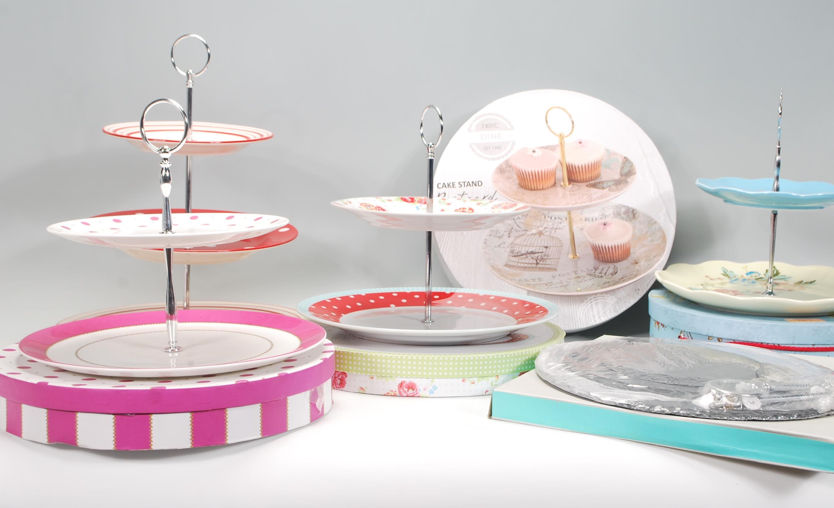 A group of six contemporary china cake stands to include a Rosies Pantry two tier cake stand, two