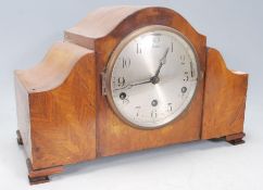 A good early 20th Century walnut cased 8 day mantel clock having inset silvered dial with Arabic