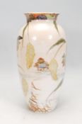 A Japanese ceramic vase of tapering cylindrical form with a flared rim being hand painted with