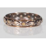 A stamped 9ct gold two tone eternity ring having pierced decoration set with white stones. Stamped