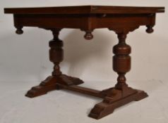 A 1930's Gothic revival oak draw leaf extending dining table having a square top with folding