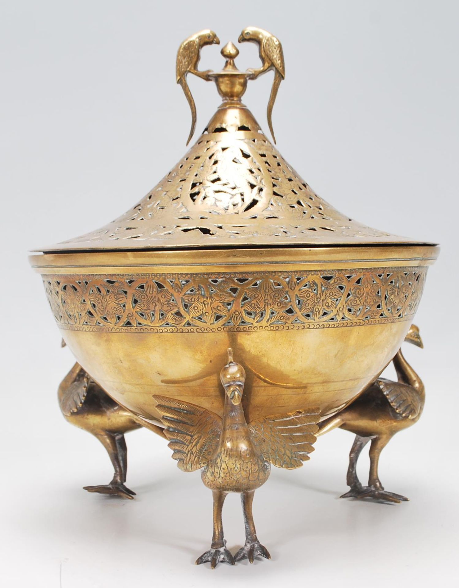 A 20th Century Indian brass centrepiece lidded bowl raised on three modelled peacocks with spread